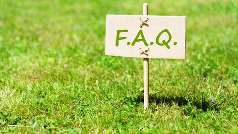 Häufig gestellte Fragen Schild mit dem Titel FAQ auf einem grünen Rasen