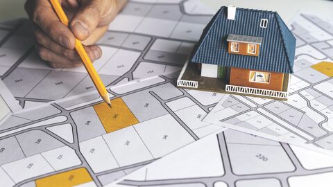 Lageplan Baugrundstücke Mann studiert einen Lageplan für Baugrundstücke