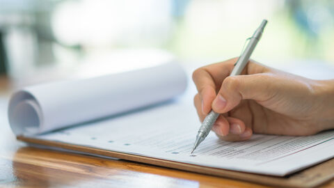 Gut vorbereitet - mit unseren Checklisten! Der Bildausschnitt zeit eine Hand, die eine Checkliste ausfüllt