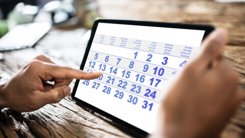 Terminkalender Mann tippt Termine auf einem Tablet PC ein.