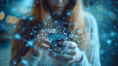 Smartphone Junge Frau benutzt ein Smartphone vor ruhigem blauen Hintergrund und überlagert mit einem stilisierten KI-Netz.
