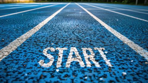 Startbahn Der Schriftzug Start auf einer blauen Tartanbahn