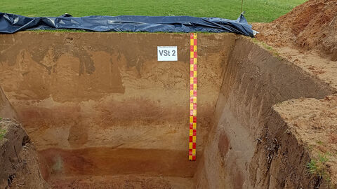 Bodenschichtprofil und angebrachte Messlatte in einer Grabung 